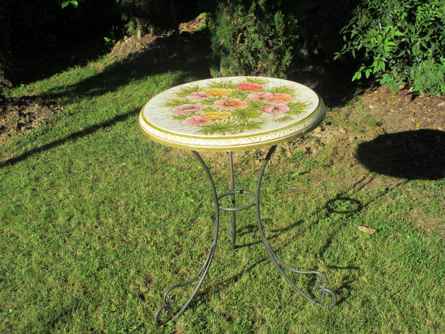 Tavolo in ceramica tondo con disegno di anemone e base in ferro